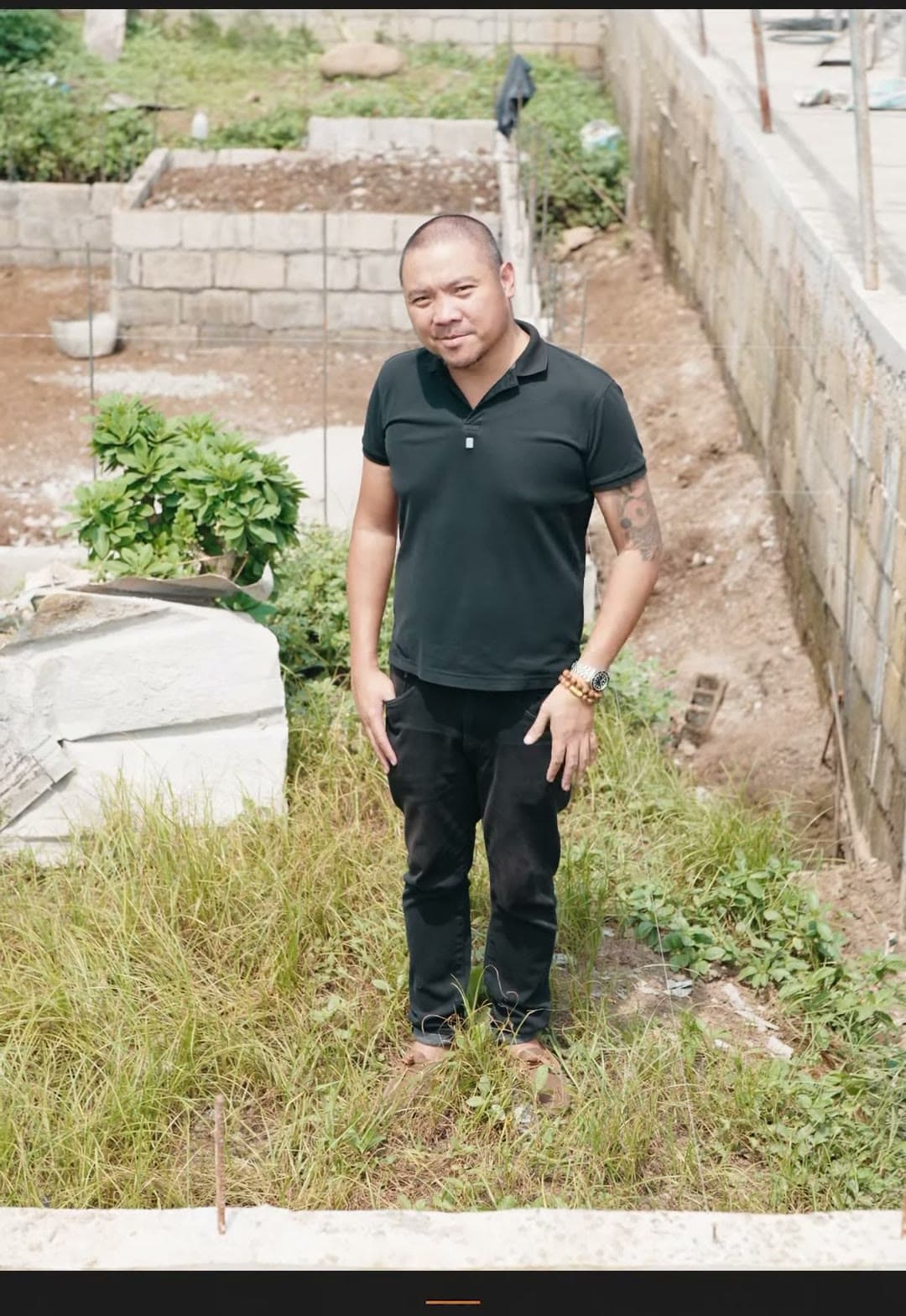 Kuya Erick standing on an empty lot ready for construction