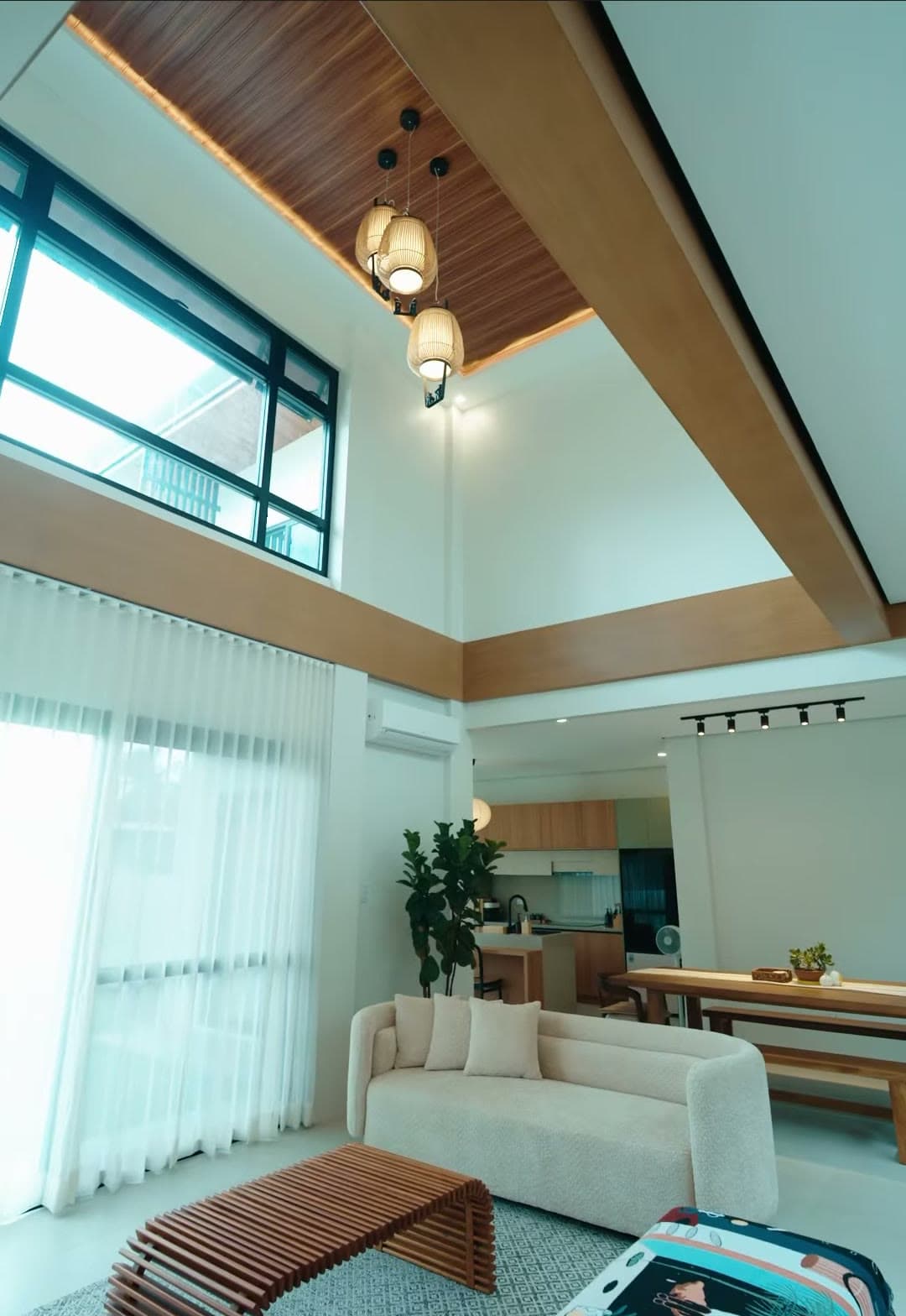 Double-height living room with sheer curtains