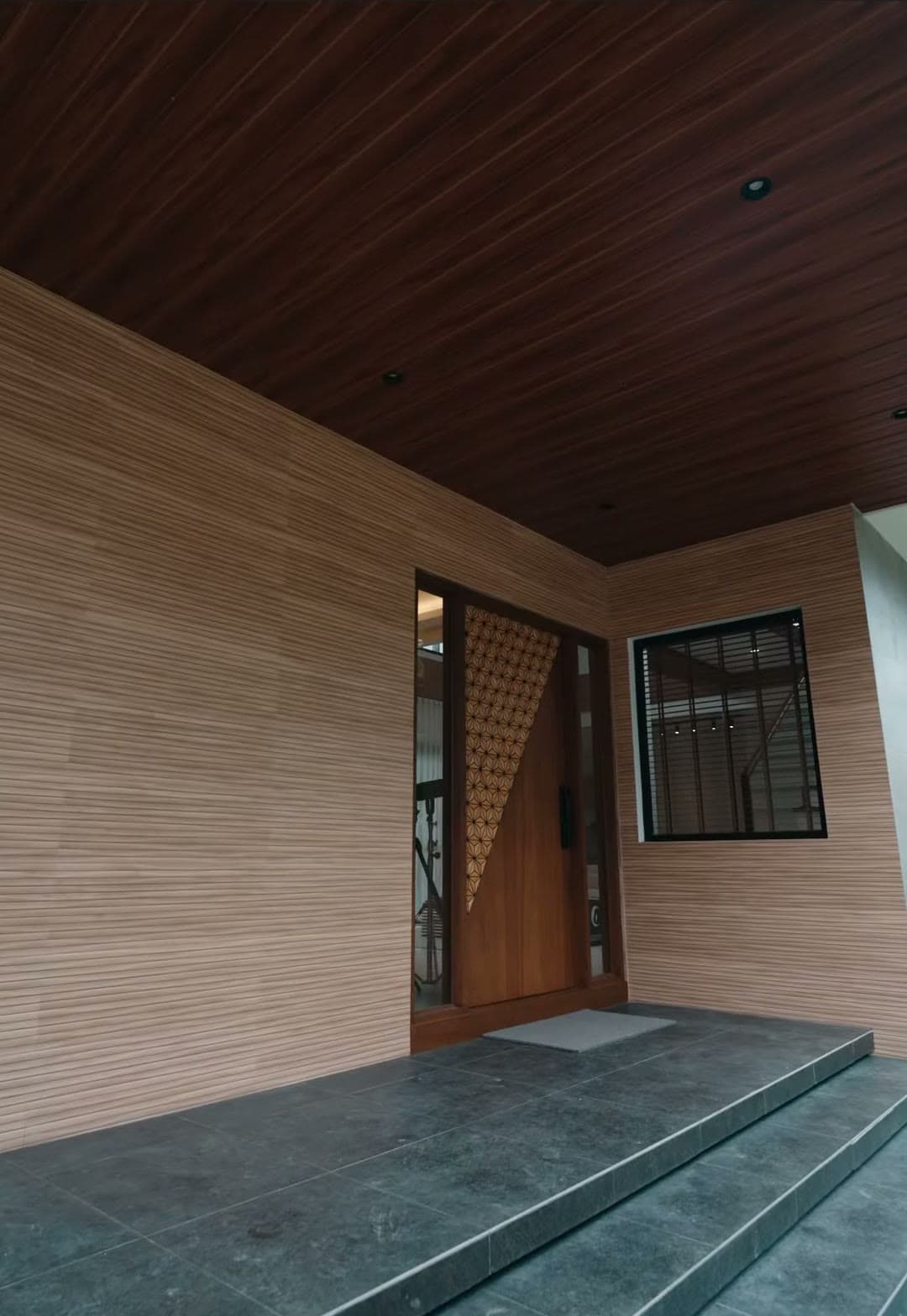 Recessed entry under a wood-lined ceiling